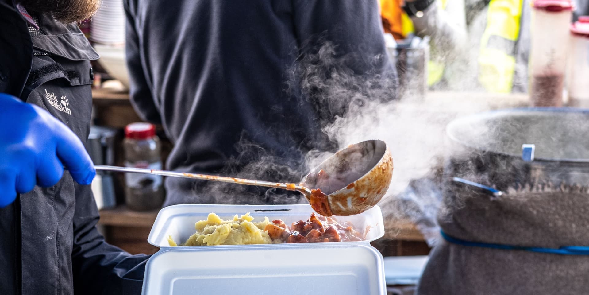 A hearty stew being ladled from a pot in a warm kitchen