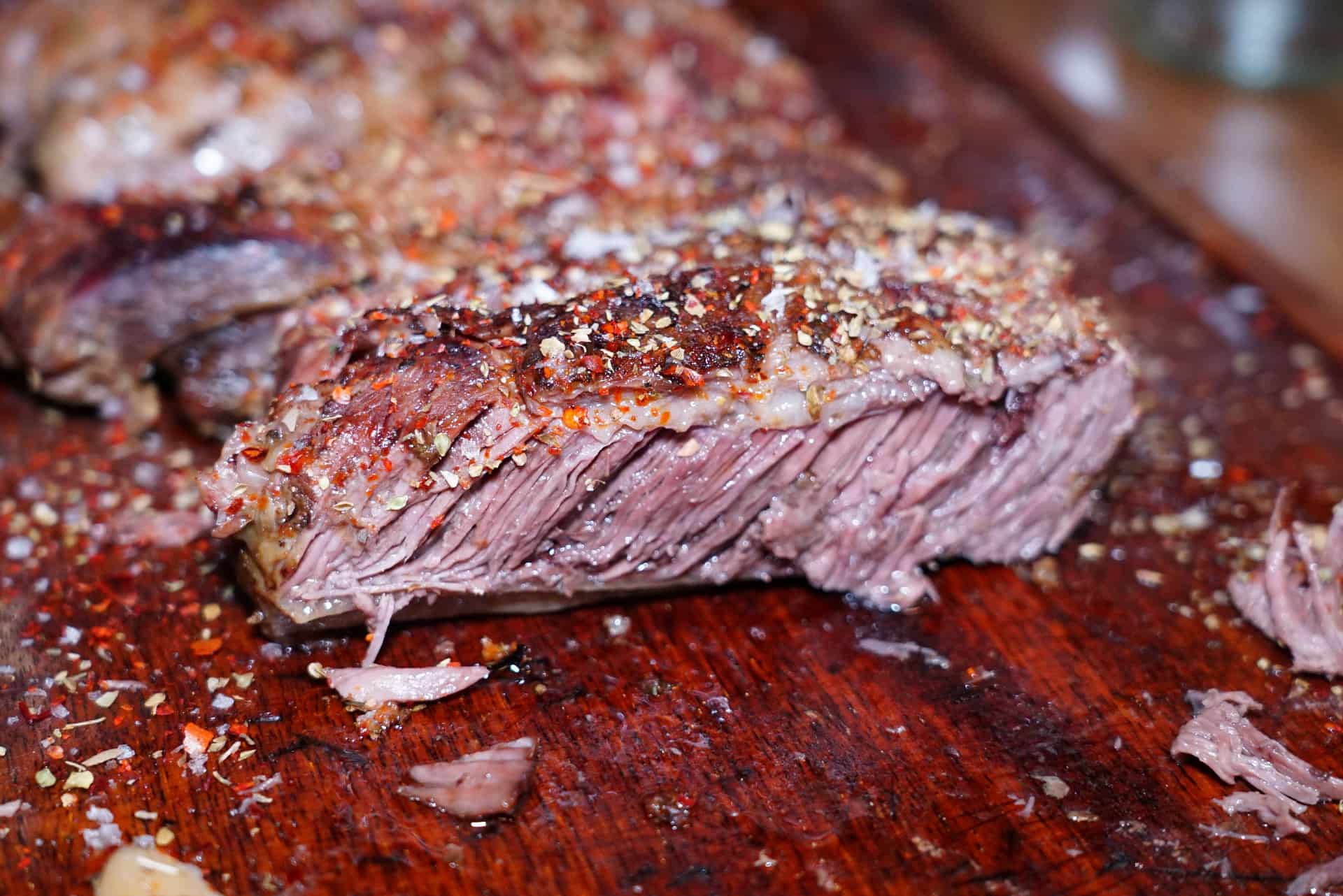 A seared steak resting on a wooden board